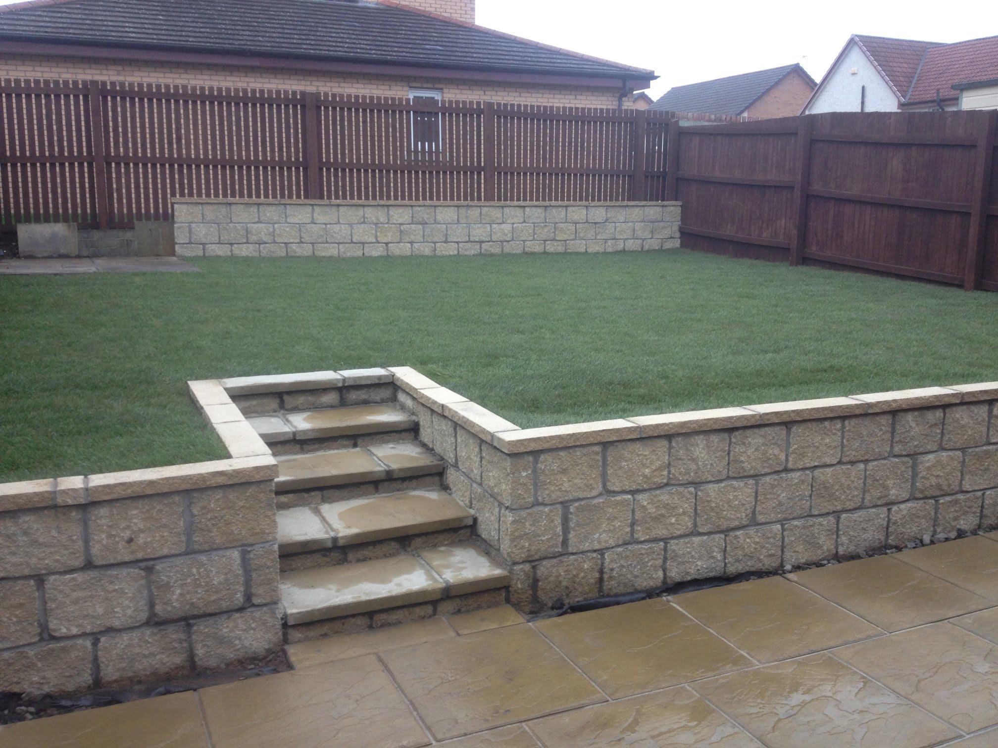 Split level rear garden with sandstone patio, walling and steps