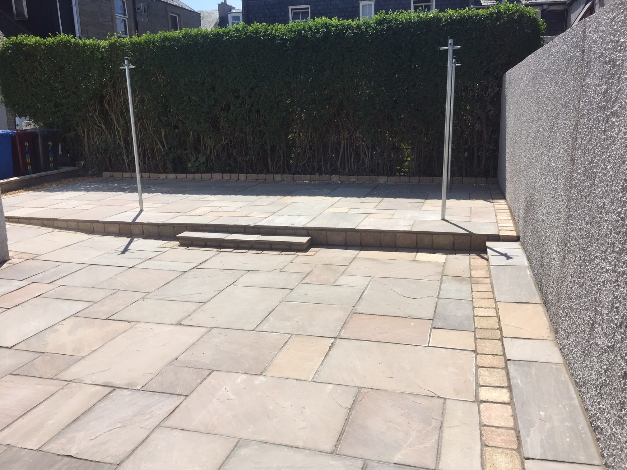 Two tier Indian sandstone patio with a sett border