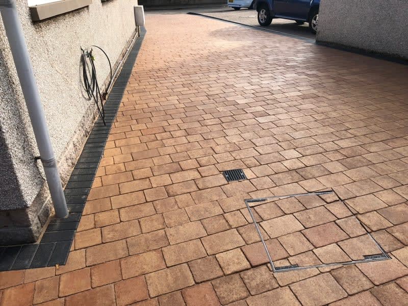 Tumbled sett driveway with a charcoal drainage edge