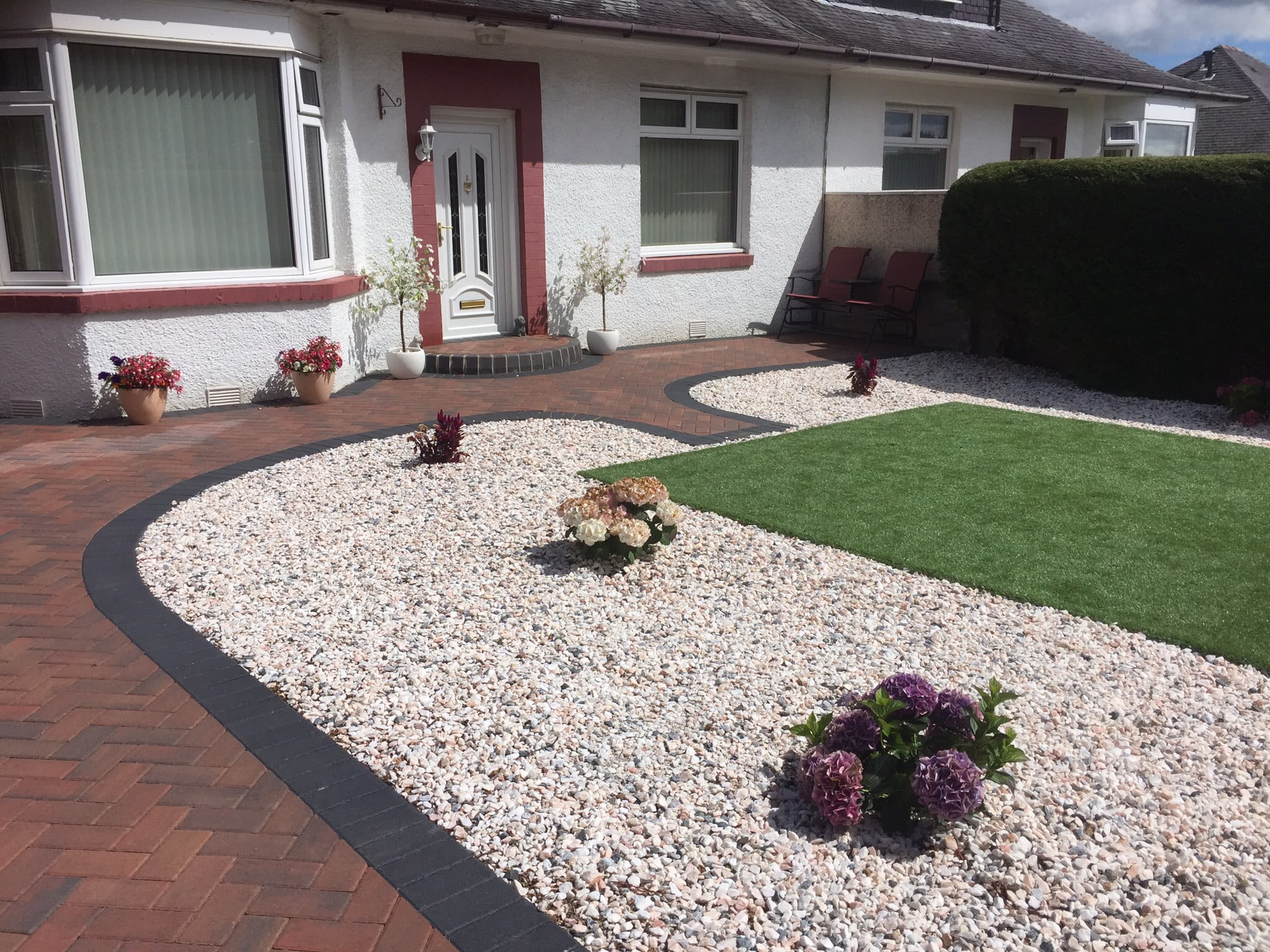 Completed front garden with red monoblock driveway, gravel beds and artificial lawn at a Dundee bungalow